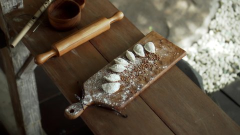 Traditional rustic Russian fresh handmade dumplings lying on the wooden table on the cutting board