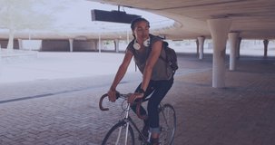 Animation of heart and data over biracial male cyclist on bike. sport, active lifestyle, competition and technology concept digitally generated video.