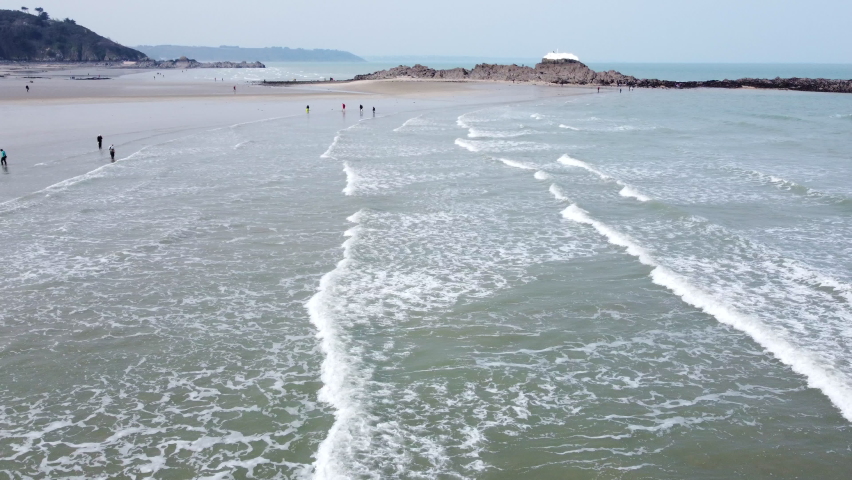 Aerial flying over Martin beach, Saint Brieuc, unrecognizable people walking on sand