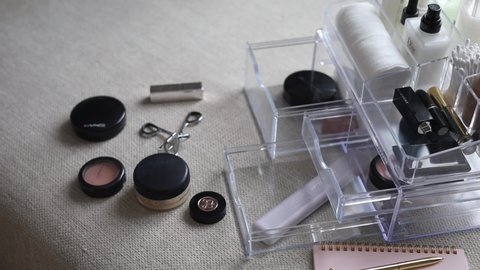 Khabarovsk, Russia, march 11, 2022. Closeup female hands putting luxury cosmetic into acrylic box with drawer storage organization. Beauty products tidying up neatly placement at minimalist container.