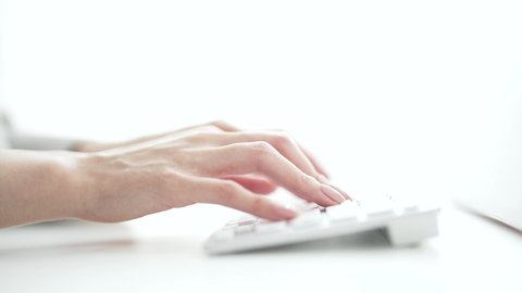 A woman's hand hitting a computer keyboard