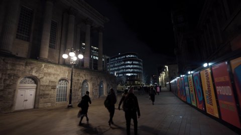 BIRMINGHAM, UK - 2022: Low aerial view of Birmingham UK at night with lots of people walking