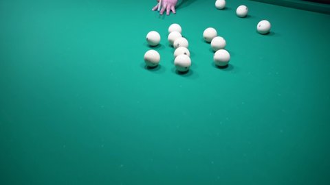A sports game of billiards, pool or snooker on a billiard table with a green cloth.Hitting billiard balls with a cue. Cue kick.Participate in games and competitions,score a goal in the pocket in match