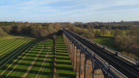 Aerial drone flyback along Ouse Valley or Balcombe viaduct surrounded by verdant landscape, Sussex. UK