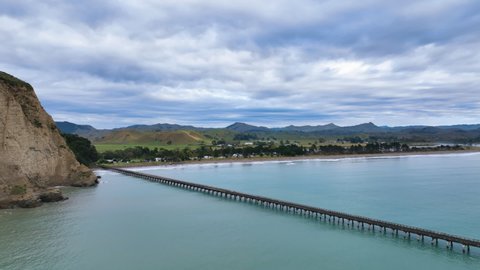 Aerial above dramatic Tolaga Bay heritage wharf and beautiful surrounds -NZ