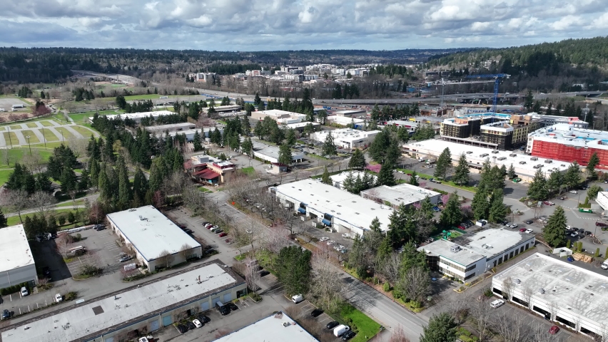 Cinematic aerial drone dolly in shot of Redmond Town Center mall with the WA-520 freeway, apartments and hotels by Marymoor Park, Lake Sammamish in Redmond, Washington, near Bellevue