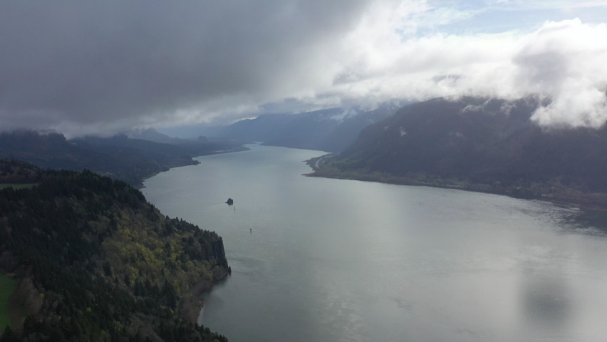 Low clouds drift over the Columbia River which runs between Oregon and Washington. The scenic Columbia River Gorge, with the Columbia River flowing through it, is over 80 miles long. Royalty-Free Stock Footage #1089262317