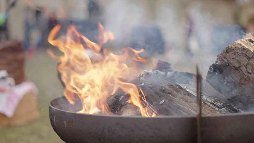flickering flames and smoke of burning bonfire in a bowl, slow motion