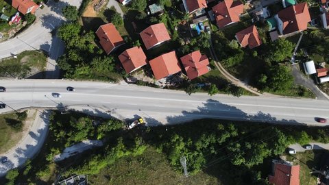 Birds Eye Aerial View of Traffic by Small Town in Serbian Countryside. Cajetina, Zlatibor Mountain Region, Serbia. Top Down Drone Shot