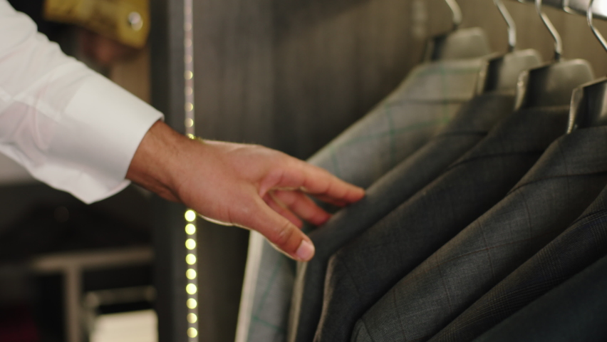 In a modern suit shop taking video closeup how client choose and looking through the new suit collection concept of design couture business and handmade suits Royalty-Free Stock Footage #1089268973