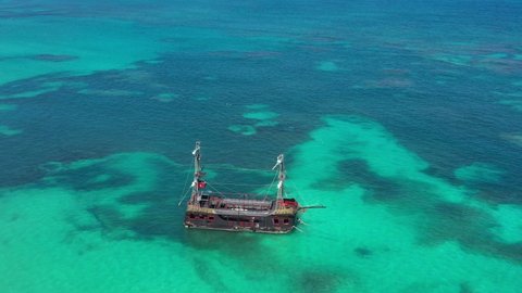 Pirate ship floating in caribbean sea. It is popular excursion for tourists. Dominican Republic. Aerial top view