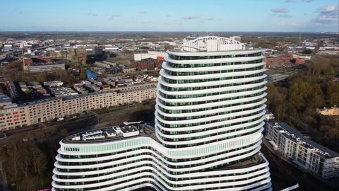 GRONINGEN, NETHERLANDS - 09. APRIL 2022: Orbiting shot of modern architecture, tax authorities office building in Groningen. The building is located at Kempkensberg and resembles a cruise ship.