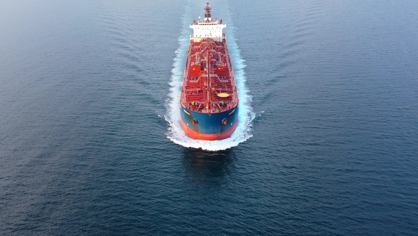 Flying over a crude oil tanker underway in open sea. Bow, forecastle, red upper deck, pipe lines, winches, wheelhouse, upper running bridge, radar mast of a supertanker ship on ride. Aerial, close up
 | Shutterstock HD Video #1089276643