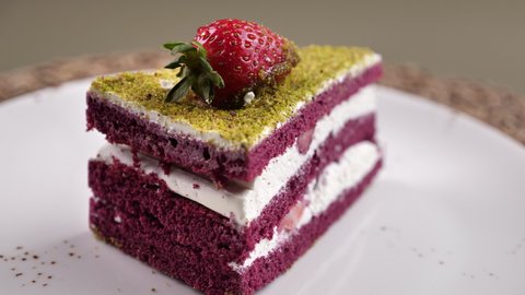 Green Pistachio Cream Slice Pie. A delicious cake slice consisting of cream, wet cake, strawberry. Presentation on a 360 turntable.