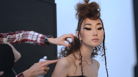 stylist fixes model's hair during photo shoot