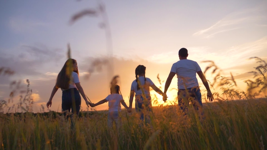 Beautiful people raise their hands up to the sun at sunset. Leisure healthy lifestyle, travel. Happy kids with parents. Happy family in the park in the open air. Royalty-Free Stock Footage #1089284595