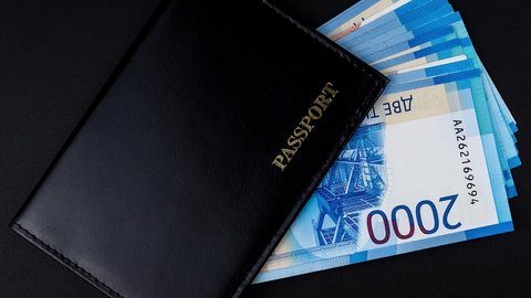 Russian passport with money inside on a black background	

