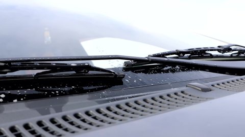 Wiper blades work when cleaning a car's windshield.