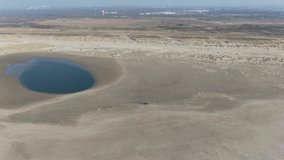 Aerial video of the dutch coastal defence project sand engine where natural forces divide sediment along the coast 