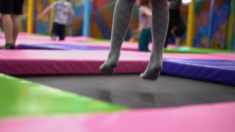 Amusement center, family park. Children jump on trampolines. Slow motion