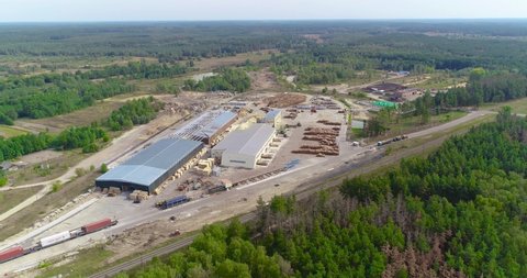 Flying over a large modern sawmill, the train stands near the sawmill view from the top. Modern woodworking factory aerial view