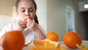 girl child eating oranges. dream happy family fruit healthy food kid concept. little girl daughter eating oranges indoors at the table in the kitchen. juicy fruits oranges are for a healthy diet - Powered by Shutterstock - Get 15% off with code: PIKWIZARD15