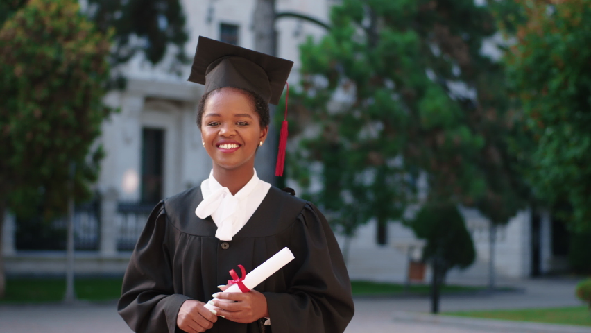 Graduation concept amazing looking lady graduate posing with her diploma in front of the camera she wearing graduation suit and cap Royalty-Free Stock Footage #1089302507