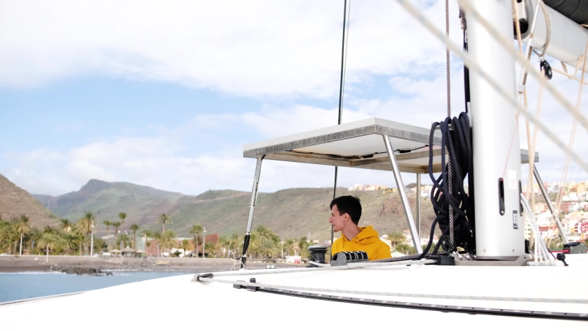 Boat captain active confidently steering sail on his yacht while the storm