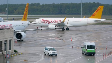 Pegasus Airlines plane in airport. Prepare jet for flight. Logistic concept. Global business, freight transportation. Manual worker and car on runway - ANTALYA, TURKEY - CIRCA JANUARY, 2022