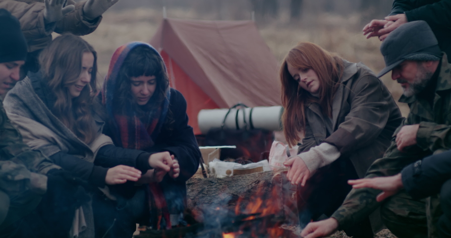 Soldier And Refugees Sitting Around Bonfire.