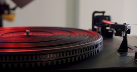 Hand turns on a vintage vinyl record and vinyl record is spinning. Slow motion