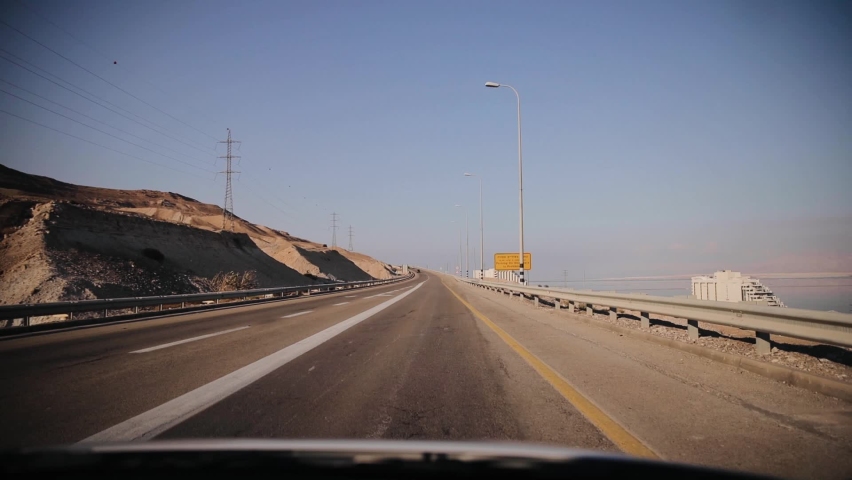 Driving through a mountain desert road, leading towards the Dead Sea. POV shot from inside the car. Highway in Israel