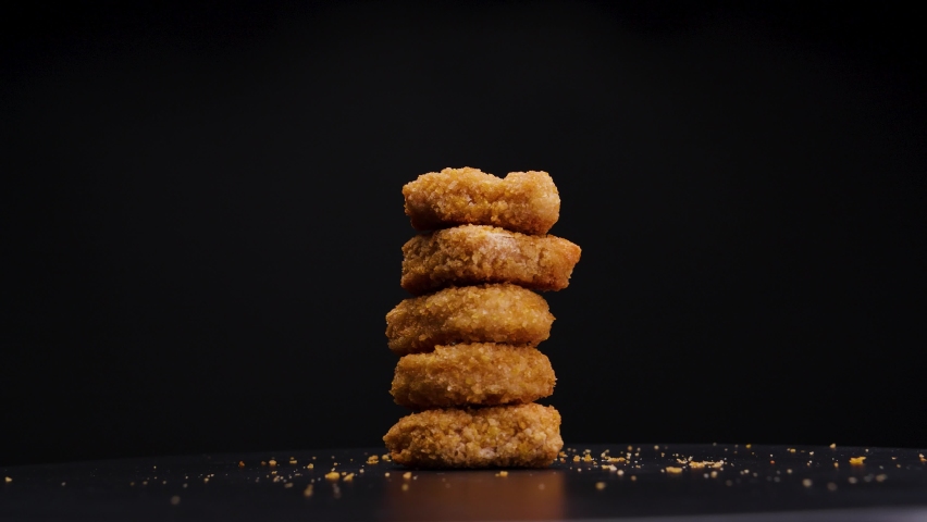 Stack of beautifully cooked vegetarian, golden brown chicken nuggets rotating against a black background, static shot | Shutterstock HD Video #1089305273