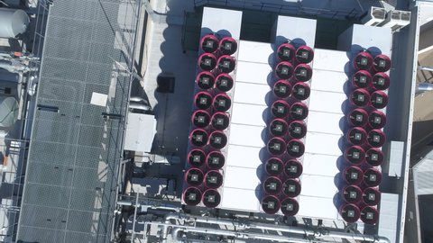 Aerial look down shot. Numerous self-contained commercial HVAC rooftop cooling systems, and airconditioning units on top of a state of the art datacenter building.
