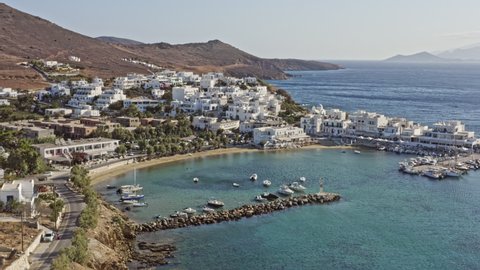 Piso Livadi Paros Greece Aerial v2 low level fly around stunning small harbor, hillside village town, panning reveals beautiful aegean seascape with endless horizon - September 2021