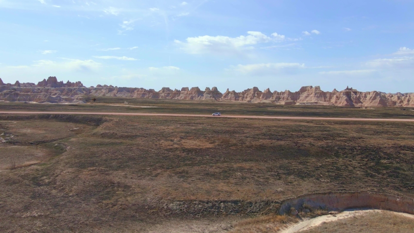 SUV driving on a dirt road alone in Badlands National Park, South Dakota. USA