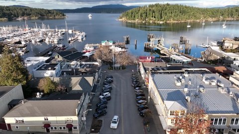 Cinematic 4K aerial drone sunset footage of Spring Street before the fire at the Port and town of Friday Harbor with the ferry terminal, commercial zone, downriggers in the San Juan Islands