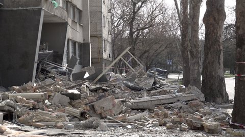 Mykolaiv , Ukraine - 03 29 2022: A Car And A Man On A Bicycle Pass A Hotel That Was Hit By A Cruise Missile