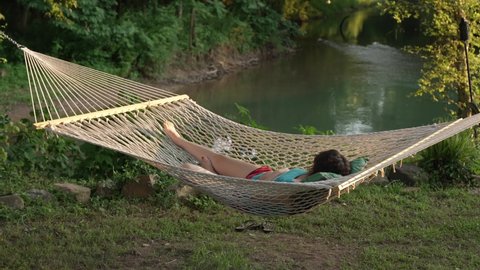Girl relaxing in a hammock by the Eleven Point River in Thomasville Missouri