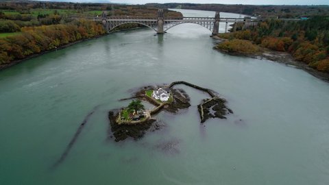 Aerial orbiting around Red Weir Island or Ynys Gored Goch in Swellies Strait and surrounding landscape. Anglesey in Wales. UK