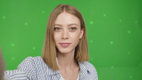 Young woman teenager speaking on video call, vlogger using smartphone talking at camera webcam online, selfie call, record lifestyle vlog, blogger online streaming on green screen . Chroma key