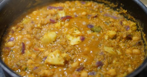 Indian Red Lentil Dhal. Vibrant red lentils simmering. Chef asian exotic recipe