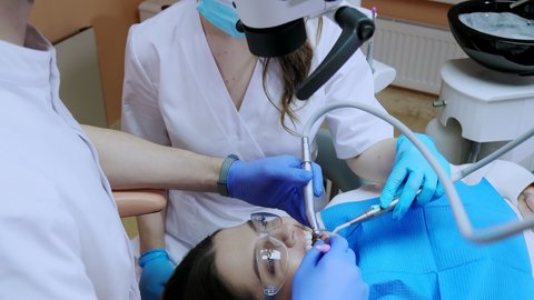 A dentist treats a woman's teeth using a cofferdam. Dental equipment.