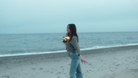 girl on the beach with a shopping bag of lights