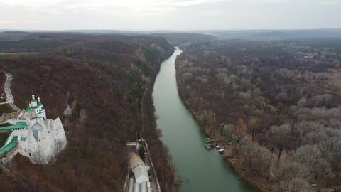 Aerial view from drone of left and right bank of Seversky Donets river in autumn and Sviatohirsk Lavra chalk cave monastery, Sviatohirsk village, Donetsk oblast, Ukraine. Seversky Donets river in fall