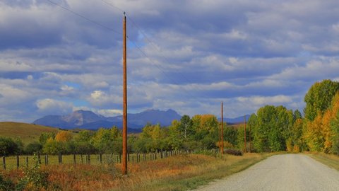 View of a gravel dirt country road in the foothills of the Canadian Rockies near Turner Valley, Alberta, Canada.