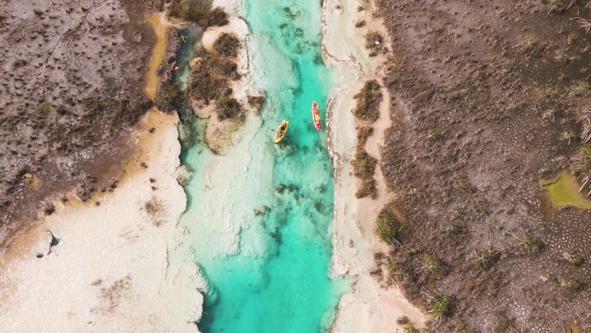 Upwards panning drone shot of kayakers revealing the scenic view of "los rapidos" rapids located in Bacalar, Mexico shot in 4k.