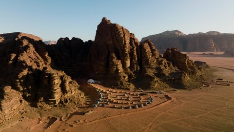 Sunlight Through Mountains With Memories Aicha Luxury Camp In Wadi Rum, Jordan. Aerial Wide Shot
