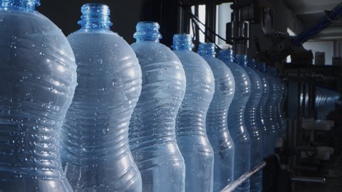 Water factory bottling pure spring water into bottles on automatic conveyor line