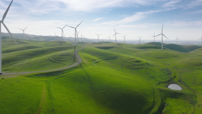 Scenic nature landscape view with wind turbines generating green renewable energy from strong wind. Cinematic aerial view of large wind turbines producing clean sustainable energy, clean energy future Royalty-Free Stock Footage #1089329513